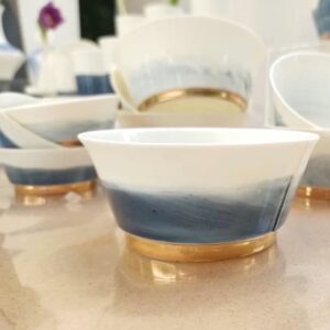 Handgemachte Porzellan Schale mit blauem und goldenem Rand auf Tisch